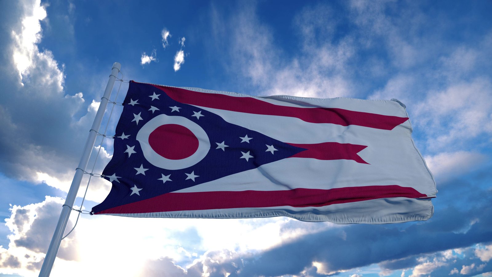 Ohio flag on a flagpole waving in the wind, blue sky background. 3d rendering.