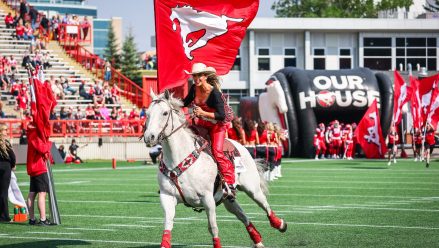 woman-riding-horse-flag-calgary-stampede-game