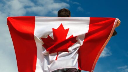 man-holding-canadian-flag-over-back