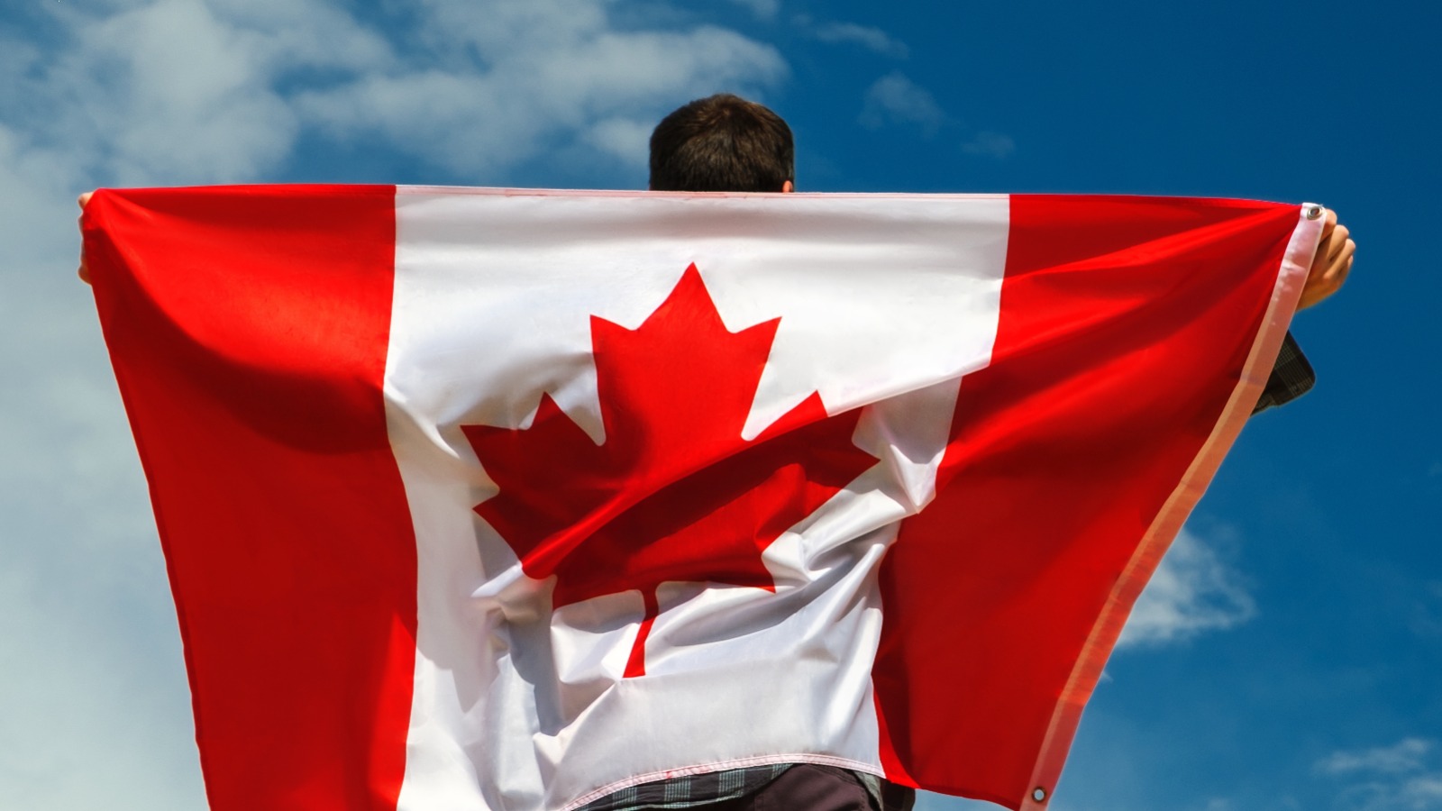 man-holding-canadian-flag-over-back